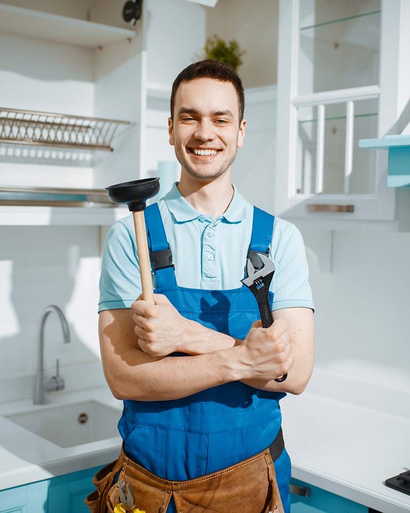 cheerful-male-plumber-holds-wrench-and-plunger-resize.jpg